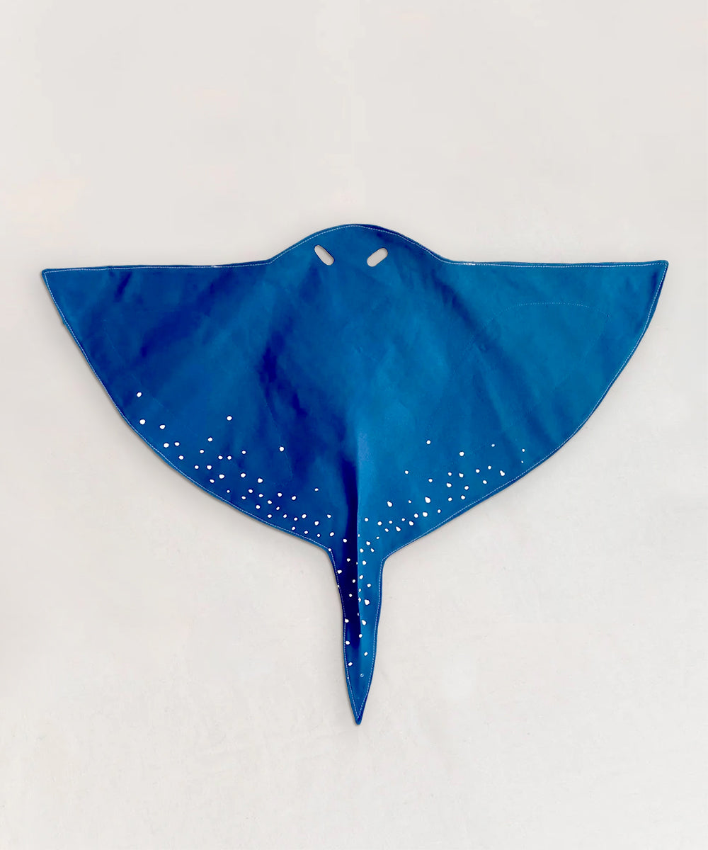 Le Stingray Costume, a blue manta ray shape with white wing spots, lying flat on a light background.