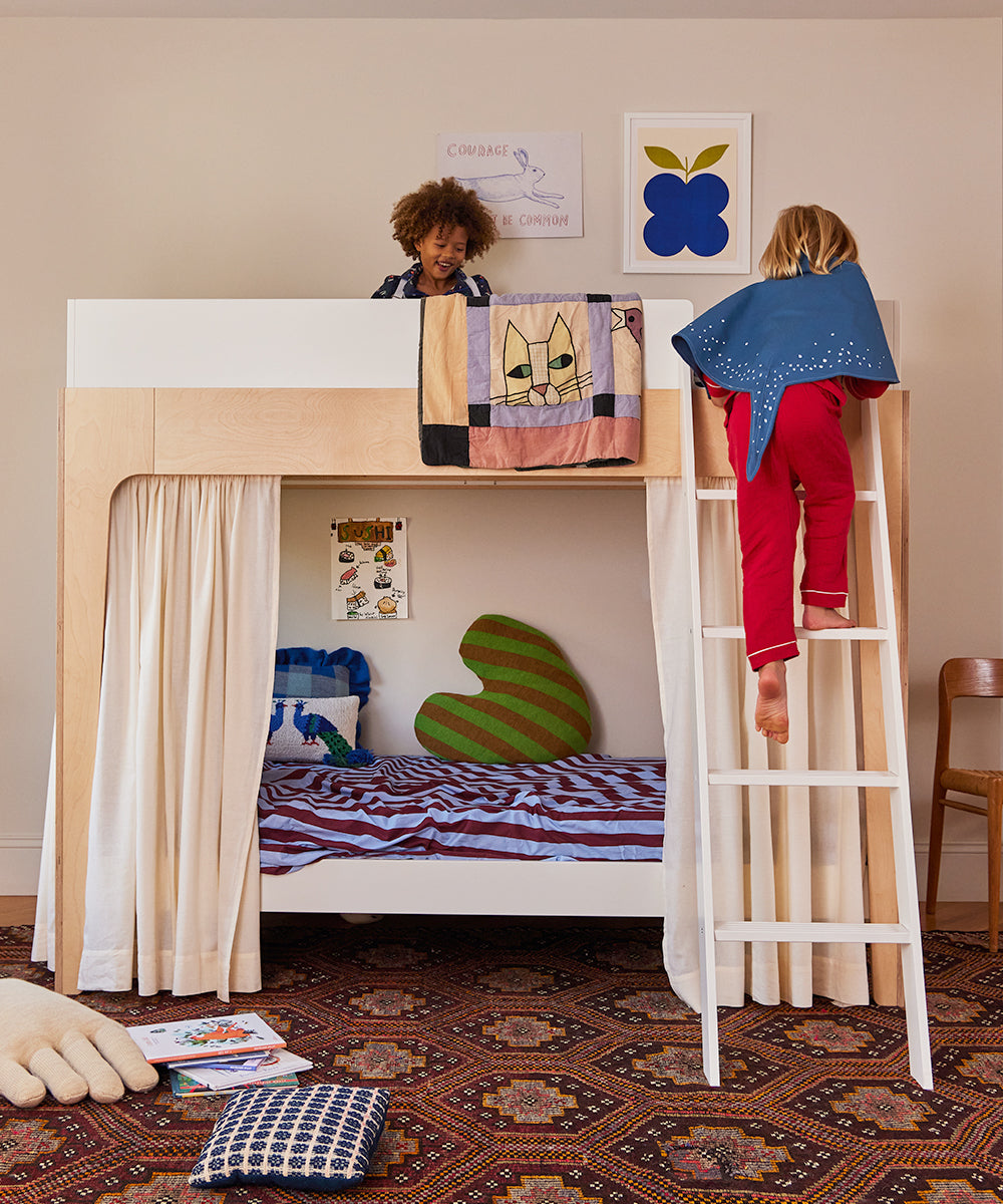 Children wearing Le Stingray Costumes playing on a bunk bed with colorful bedding and posters in a cozy, carpeted room.